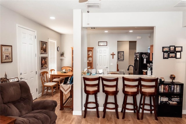 living room with sink and light hardwood / wood-style flooring