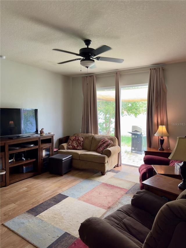 living room featuring hardwood / wood-style flooring, a textured ceiling, and ceiling fan