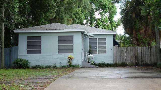 view of front of house with stone siding, entry steps, and fence