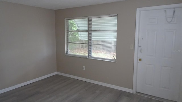 spare room featuring baseboards and wood finished floors