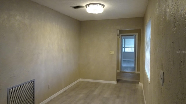 unfurnished room with visible vents, baseboards, and light wood-style floors