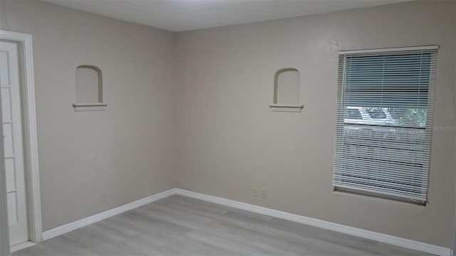 unfurnished room with light wood-style flooring and baseboards