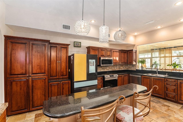 kitchen featuring stainless steel appliances, a kitchen island, a kitchen breakfast bar, and sink