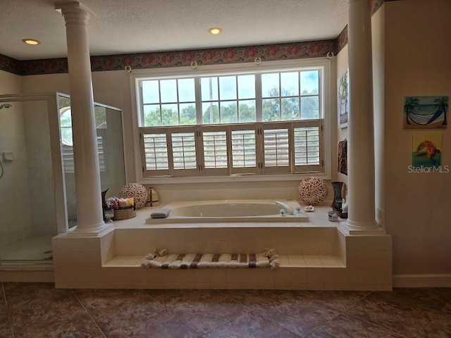 bathroom with decorative columns, a textured ceiling, independent shower and bath, and plenty of natural light