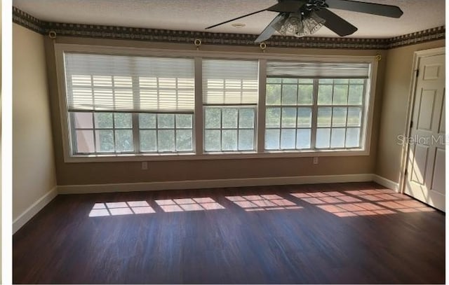 spare room featuring hardwood / wood-style flooring, a textured ceiling, and a wealth of natural light