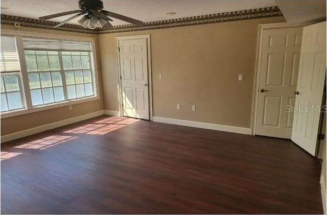 spare room with dark wood-type flooring, a textured ceiling, and ceiling fan