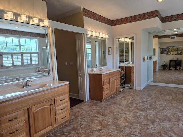 bathroom featuring vanity, a textured ceiling, and a bathing tub