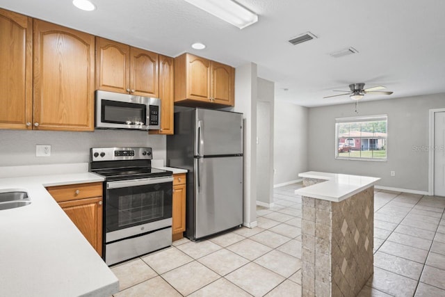 kitchen featuring light tile patterned floors, sink, ceiling fan, and appliances with stainless steel finishes