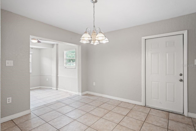 empty room featuring light tile patterned flooring and an inviting chandelier