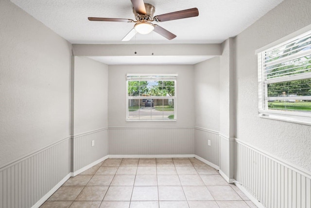 unfurnished room featuring light tile patterned floors, a textured ceiling, and ceiling fan