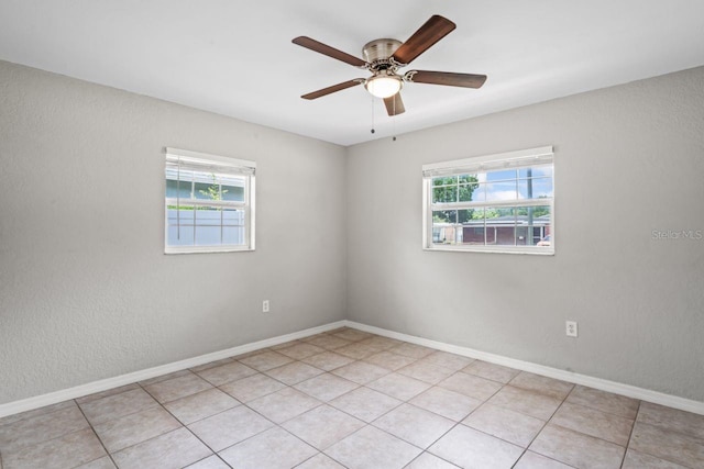 tiled spare room with ceiling fan