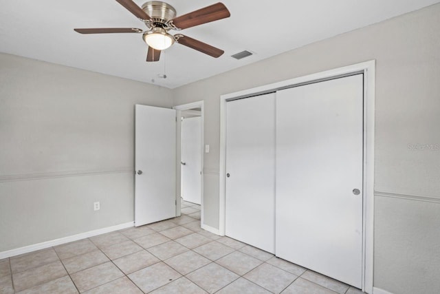 unfurnished bedroom with light tile patterned floors, a closet, and ceiling fan