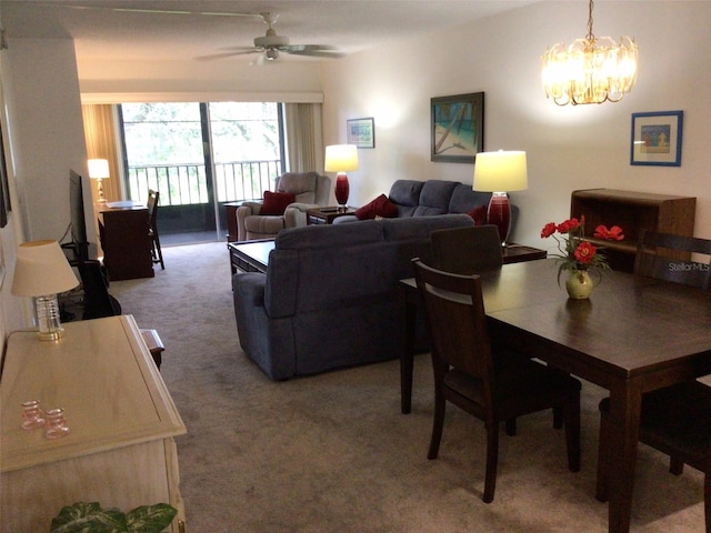 dining area with carpet flooring and ceiling fan with notable chandelier