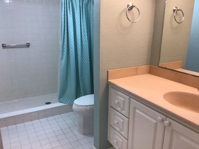 bathroom with a textured wall, toilet, a shower stall, vanity, and tile patterned floors