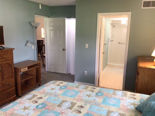 bedroom with connected bathroom and tile patterned floors