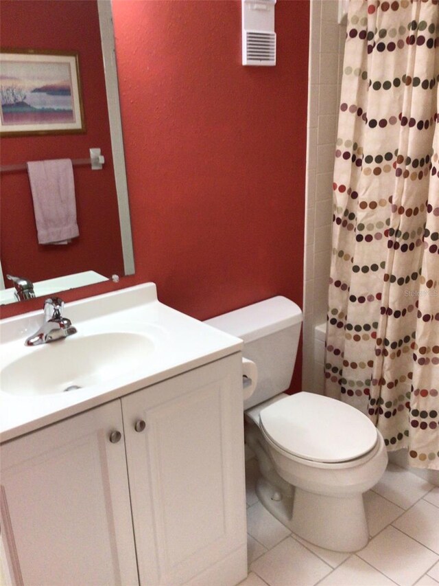 bathroom with toilet, vanity, and tile patterned floors