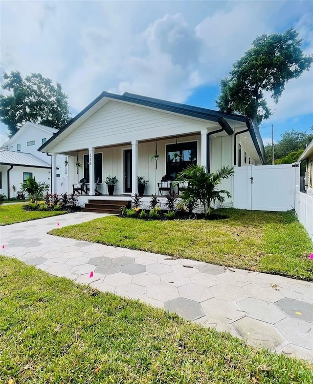 view of front of house with a porch and a front lawn