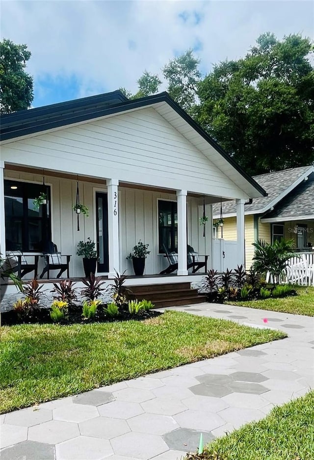 view of front of property featuring covered porch and a front yard