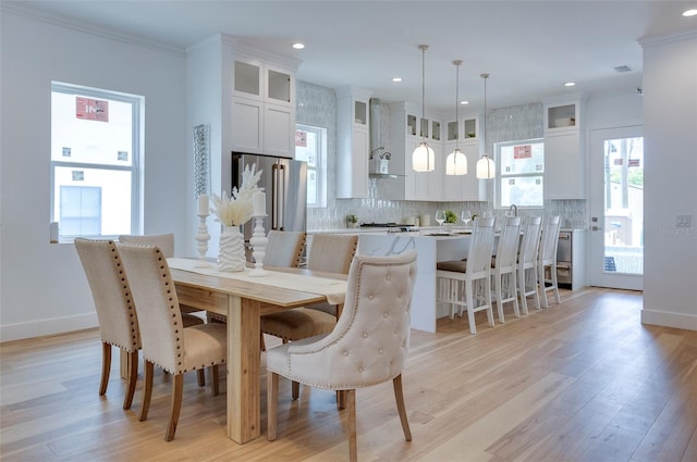 dining area featuring light hardwood / wood-style floors and ornamental molding