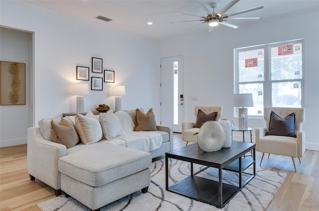 living room featuring ornamental molding, ceiling fan, and light hardwood / wood-style flooring