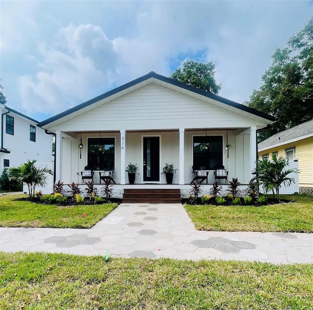 view of front of house with covered porch and a front yard