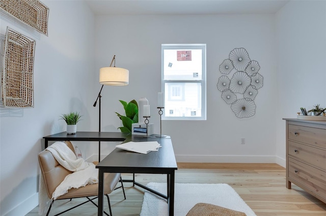 office space with light wood-style flooring and baseboards