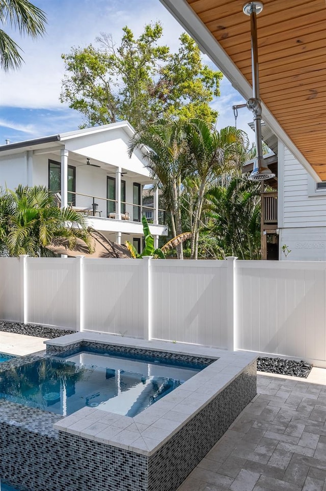 view of swimming pool featuring a patio area, a fenced backyard, a fenced in pool, and a hot tub