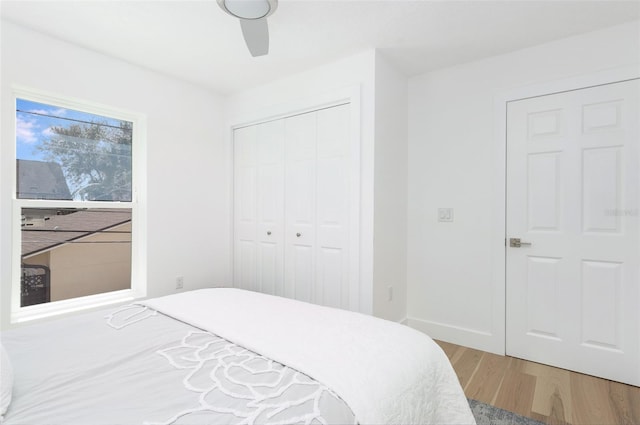 bedroom featuring baseboards, a closet, a ceiling fan, and wood finished floors