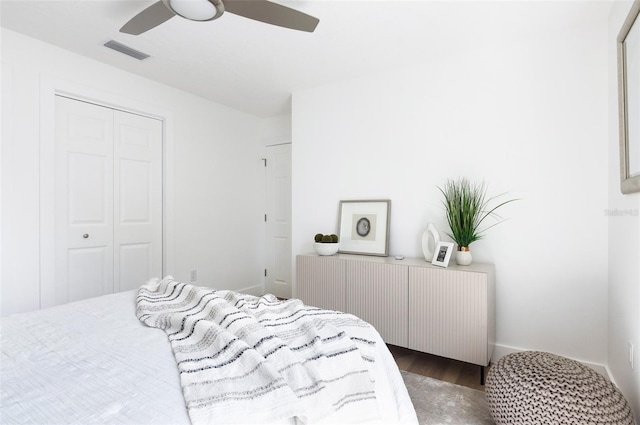 bedroom with ceiling fan, a closet, wood finished floors, and visible vents