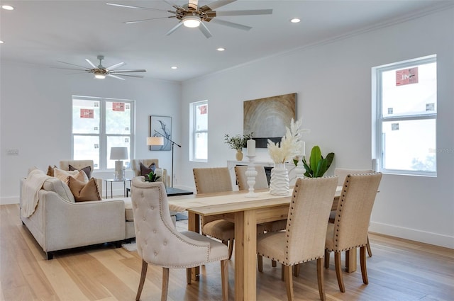 dining space featuring ornamental molding, baseboards, a healthy amount of sunlight, and light wood finished floors