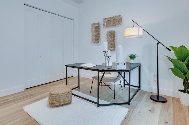 office space with light wood-type flooring and baseboards