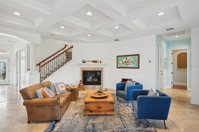 living room with a tile fireplace, coffered ceiling, ornate columns, beamed ceiling, and light tile patterned flooring