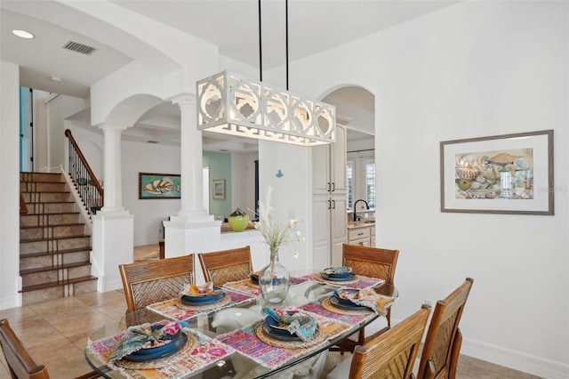 tiled dining space with decorative columns and sink