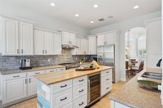 kitchen with white cabinets, appliances with stainless steel finishes, sink, and beverage cooler