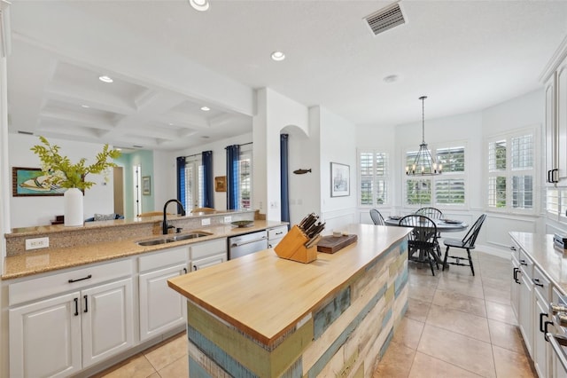 kitchen with white cabinetry, a center island, sink, coffered ceiling, and beamed ceiling