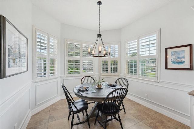 dining room with light tile patterned floors and a notable chandelier