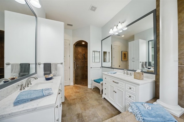 bathroom with a shower, vanity, and ornate columns