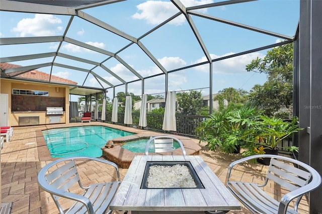 view of pool featuring a lanai, an in ground hot tub, a grill, a patio area, and exterior kitchen