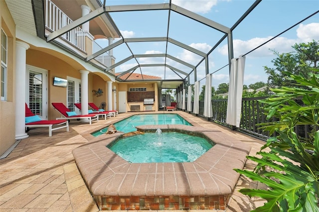 view of swimming pool featuring glass enclosure, grilling area, pool water feature, an in ground hot tub, and a patio