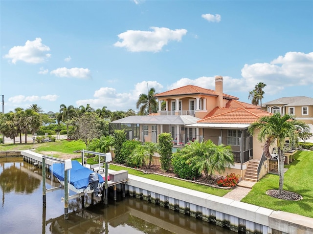 rear view of property featuring a lawn, a water view, and a balcony