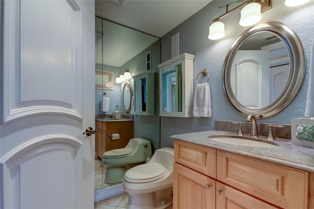 bathroom featuring tile patterned flooring, vanity, and toilet