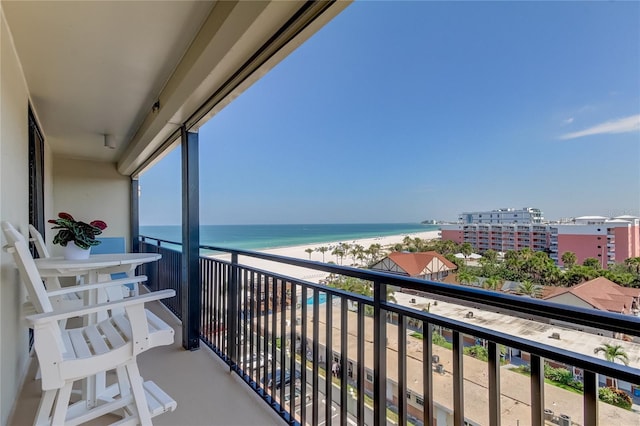 balcony with a water view and a view of the beach