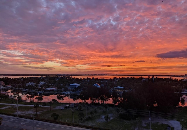 aerial view at dusk featuring a water view