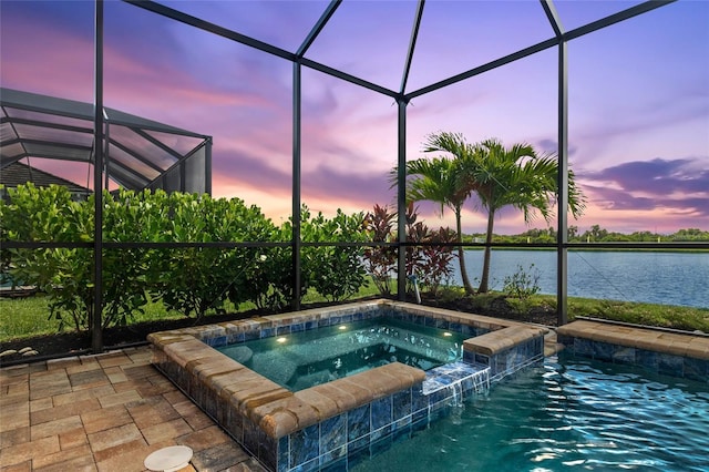 pool at dusk featuring a water view, an in ground hot tub, and glass enclosure