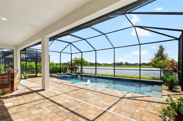 view of pool featuring an in ground hot tub, a water view, a patio, and glass enclosure