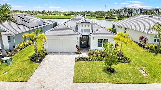 view of front facade featuring a garage, a water view, and a front yard