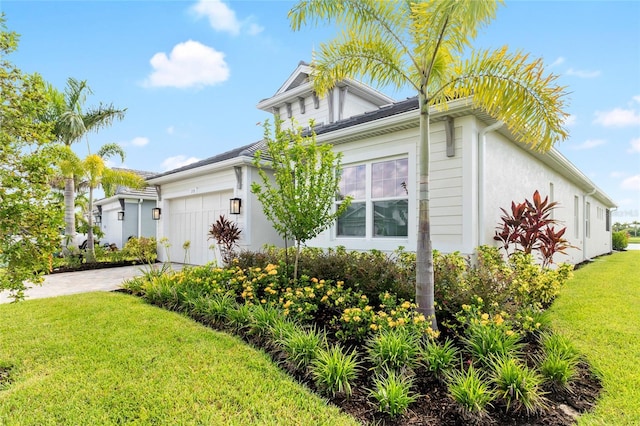 view of side of home with a yard and a garage