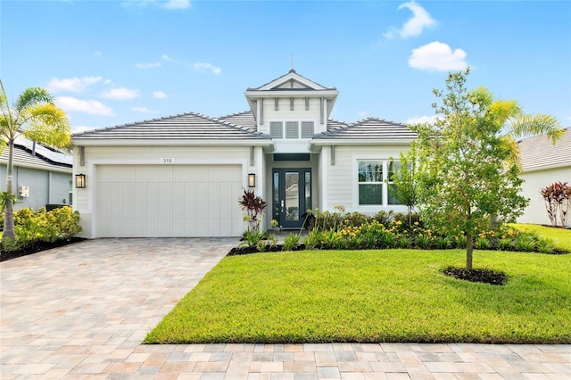 view of front of property with a garage and a front lawn