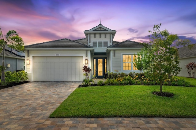 view of front of home with a garage and a yard