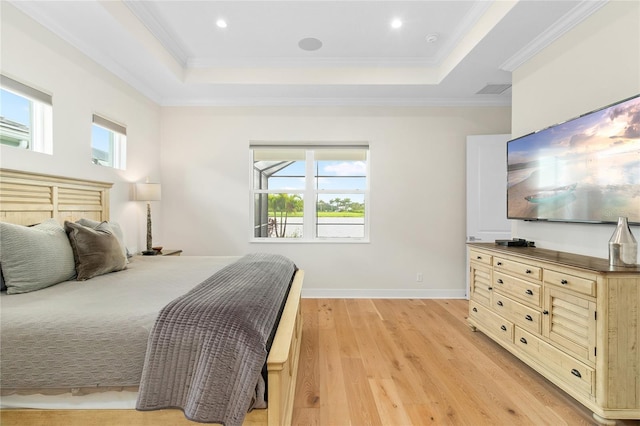 bedroom with a raised ceiling, ornamental molding, and light wood-type flooring